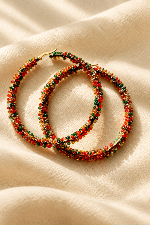 Multicolor beaded hoop earrings on warm cream fabric