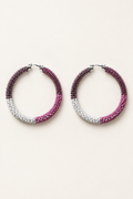 Pink, mauve, and white beaded hoop earrings on an ivory background