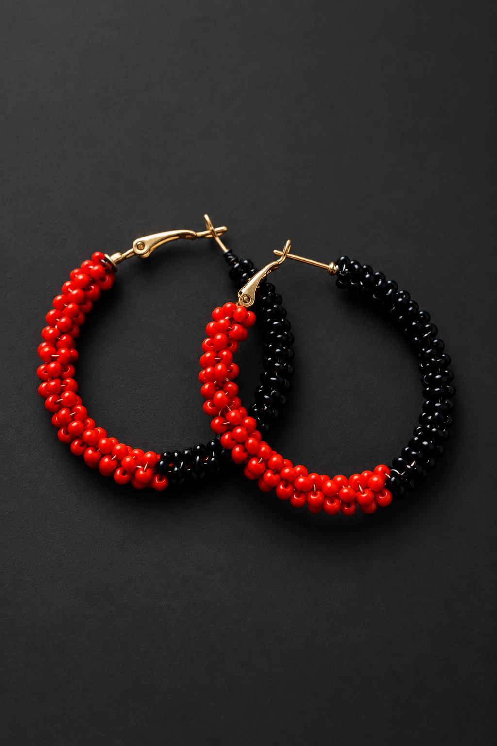 Red and black beaded earrings on a charcoal background