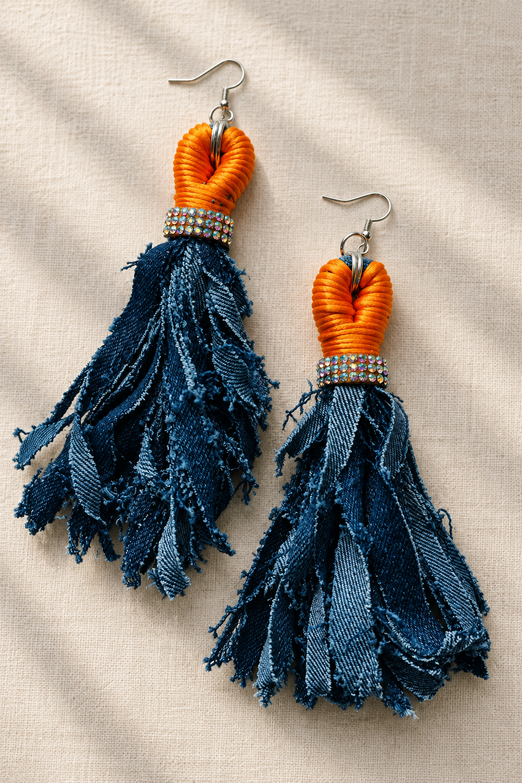 Ruth’s Radiance orange and navy tassel earrings arranged in an offset composition
